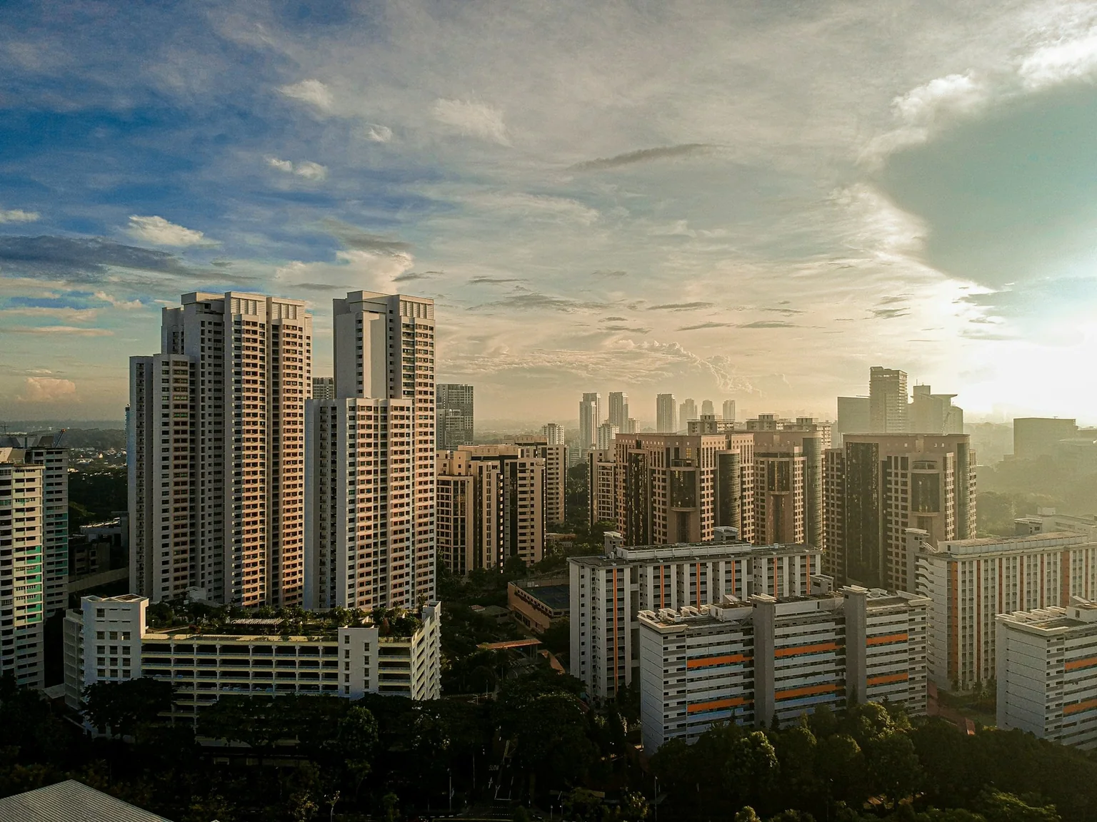 Singapore apartment blocks along Dover Road in warm evening light.
